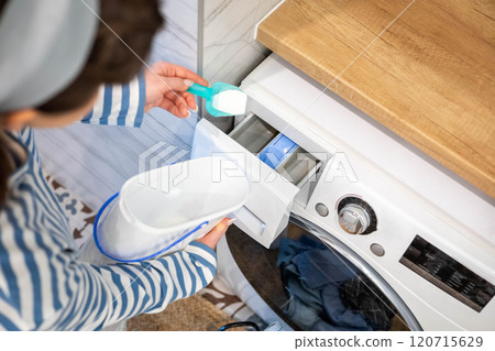 Woman housewife hands adding dry washing powder to washer machine laundry household routine Woman housewife hands adding dry washing powder to washer machine laundry household routine 120715629