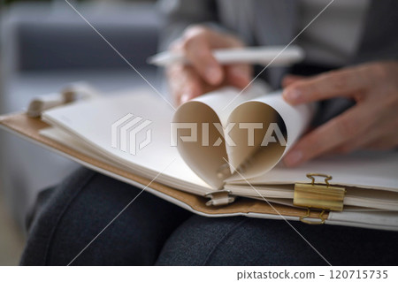 Business woman hands planning making notes in notepad paper sheet heart shape symbol of love closeup 120715735
