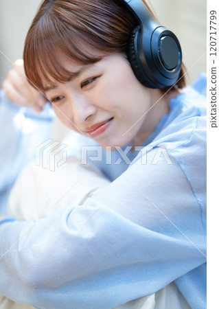 A young woman listening to music with headphones 120717799