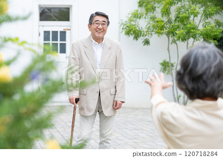 Senior couple walking with a cane 120718284