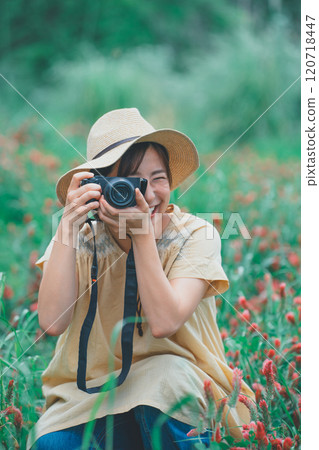 A young woman taking a picture of a strawberry candle with a mirrorless single-lens reflex camera 120718447