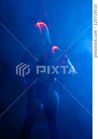 Dancer performing on stage with vibrant lights during a late-night show Dancer performing on stage with vibrant lights during a late-night show 120719510