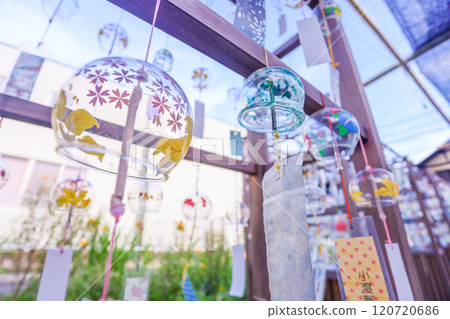 Colorful wind chimes swaying in the summer afternoon breeze under a blue sky Colorful wind chimes swaying in the summer afternoon breeze under a blue sky 120720686