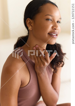 Woman Smiling Gently While Applying Neck Skin Care Routine 120722151