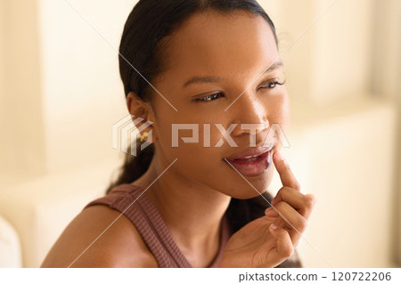 Lip Care Routine: Woman Applying Moisturizer with Thoughtful Expression 120722206