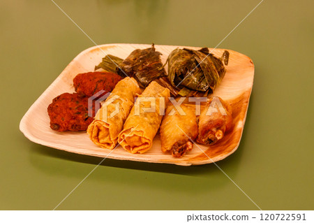 Set of thai food (fried chicken wrapped in pandan leaves, chicken wings, vegetable spring rolls, thai shrimp cake) on a table 120722591