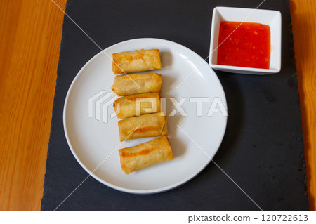 Vegetable filled thai spring rolls and sweet chili sauce on a table. Top view 120722613