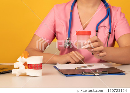 Anatomical lumbar disc herniation model in doctor hand while consultation in medical clinic. woman hand hold test tube. Intervertebral hernia treatment 120723134