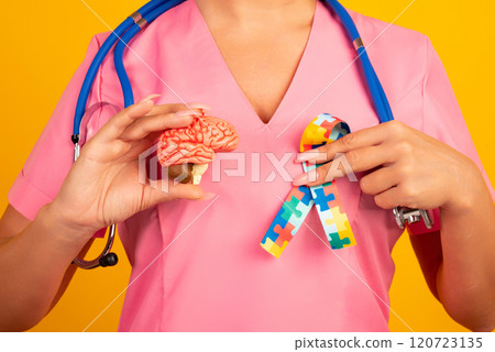 Female doctor is holding anatomical model human brain with Puzzle pattern ribbon . Help and care concept 120723135