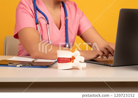 Anatomical lumbar disc herniation model on work desk of doctor in medical clinic. Intervertebral hernia treatment Anatomical lumbar disc herniation model on work desk of doctor in medical clinic. Intervertebral hernia treatment 120723152