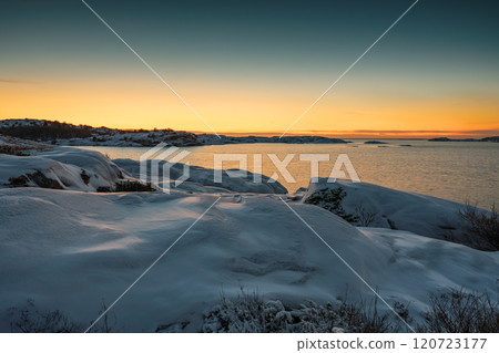A tranquil winter landscape with a winter beach, sunset and snowy scenery 120723177