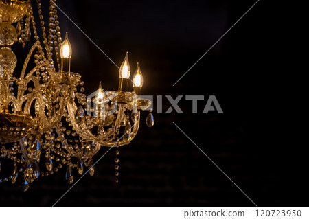 Elegant crystal chandelier illuminating darkness in luxury setting Elegant crystal chandelier illuminating darkness in luxury setting 120723950