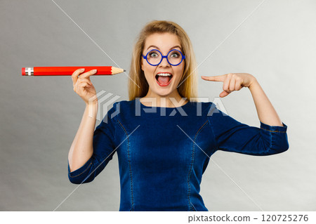 Joyful woman holds big pencil in hand Joyful woman holds big pencil in hand 120725276
