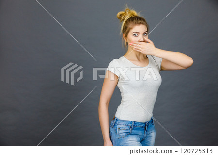 Woman covering her mouth with hand 120725313