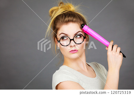 Woman holding big oversized pencil thinking about something 120725319