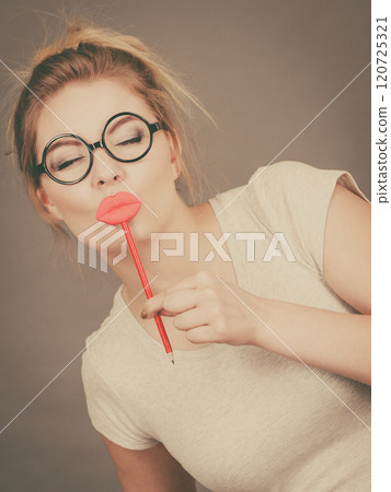 Happy woman holding fake lips on stick Happy woman holding fake lips on stick 120725321