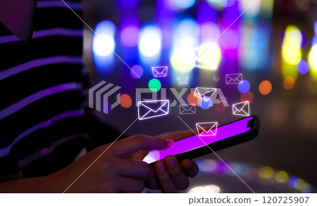 Email notification alert concept. Woman uses a smartphone with glowing email icons above screen, representing digital communication and email notifications against vibrant, online correspondence. 120725907