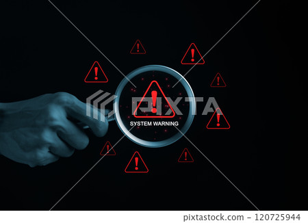 System Warning Alert, Cyber Security Concept. Hand holds magnifying glass over digital warning sign with red exclamation marks, system warning or potential malicious cyber attack alert. Cybersecurity, 120725944