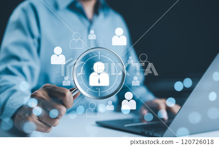 HR, Human Resources Concept. HR professional holding magnifying glass with icons of a person, symbolizing the concept of targeting or selecting the right candidate in human resources and recruitment. 120726018