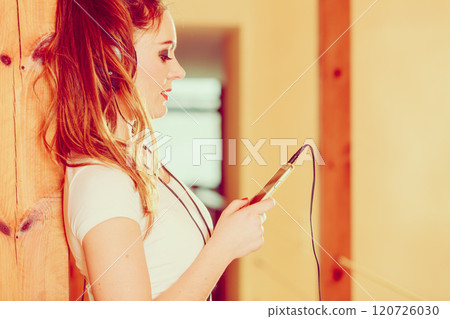 Woman with headphones choose music on smartphone. 120726030