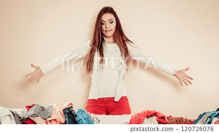 Worried young woman with sofa full of clothes. Worried young woman with sofa full of clothes. 120726076