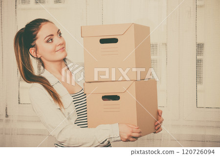 Woman moving into apartment house carrying boxes. Woman moving into apartment house carrying boxes. 120726094