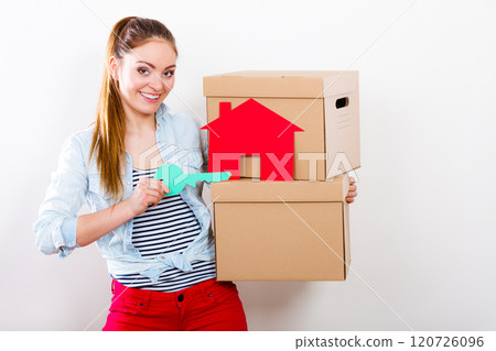 Woman moving in with boxes and paper house key. Woman moving in with boxes and paper house key. 120726096