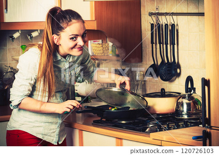 Woman frying frozen vegetables. Stir fry. 120726103