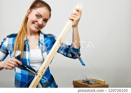 Woman assembling wooden furniture. DIY. Woman assembling wooden furniture. DIY. 120726105