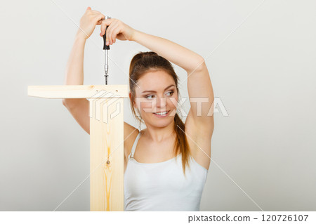 Woman assembling wooden furniture. DIY. Woman assembling wooden furniture. DIY. 120726107