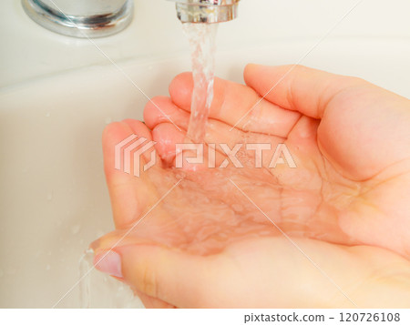 Woman washing hands under flowing tap water Woman washing hands under flowing tap water 120726108