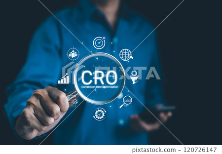 CRO, Conversion Rate Optimization Concept. Businessman holding magnifying glass focusing on the text "CRO" with digital icons representing conversion rate optimization strategies. Business strategy, CRO, Conversion Rate Optimization Concept. Businessman holding magnifying glass focusing on the text "CRO" with digital icons representing conversion rate optimization strategies. Business strategy, 120726147