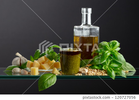 Pesto sauce and ingredients on a glass table. Pesto sauce and ingredients on a glass table. 120727056