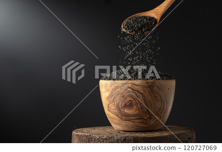 Black sesame is poured in wooden bowl. 120727069