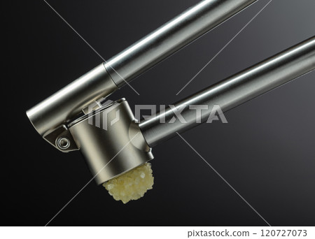 Garlic press on a black background. Garlic press on a black background. 120727073