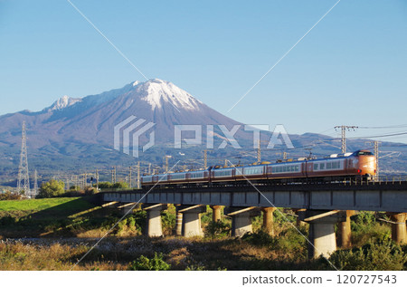 The latest 273 series Yakumo Express No. 22 bound for Okayama speeds across the Hinogawa Bridge towards the foot of Mt. Oyama, covered in its first snowfall. 120727543