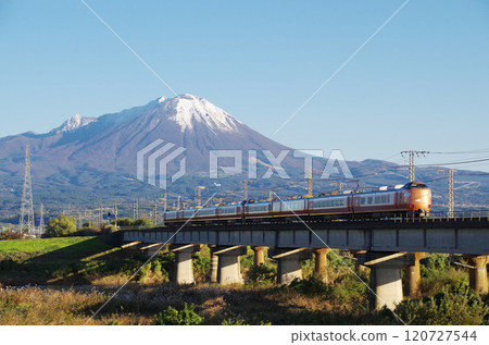 The latest 273 series Yakumo Express No. 22 bound for Okayama speeds across the Hinogawa Bridge towards the foot of Mt. Oyama, covered in its first snowfall. 120727544