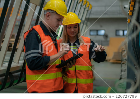 Workers collaborating in a factory setting. Workers collaborating in a factory setting. 120727799