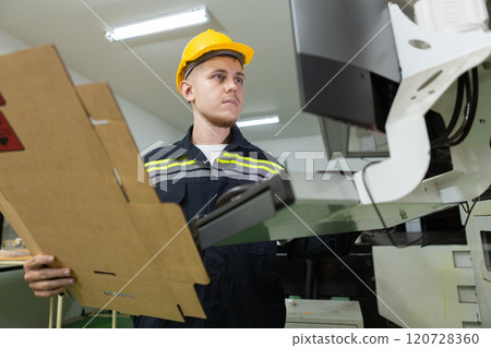 Man paper warehouse worker check quality and quantity cardboard corrugated carton in storage stock product with computer system . Large industry in paper production line. Man paper warehouse worker check quality and quantity cardboard corrugated carton in storage stock product with computer system . Large industry in paper production line. 120728360