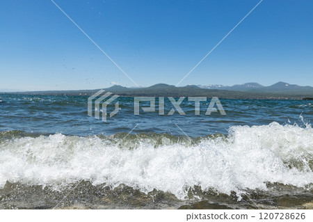 Waves crashing gently at Sevan Lake under a clear blue sky in Armenia on a sunny day 120728626