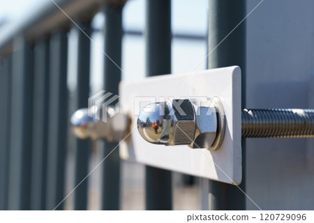 Close-up of a fence together bolted to a metal structure 120729096