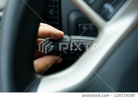 A man's hand turns on the windshield wiper switch control lever in a truck 120729100
