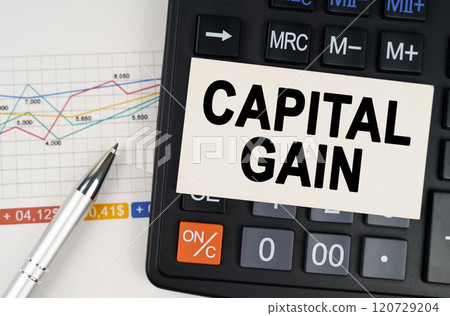 On the business chart lies a pen, a calculator and a business card with the inscription - capital gain 120729204