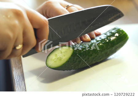 A little boy cuts a cucumber with a knife. A little boy cuts a cucumber with a knife. 120729222