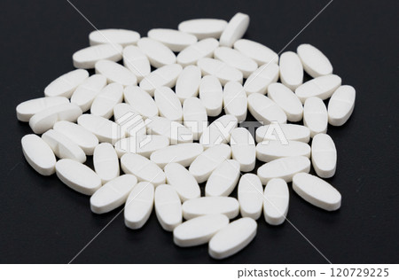 White pills lie on a black background. White pills lie on a black background. 120729225