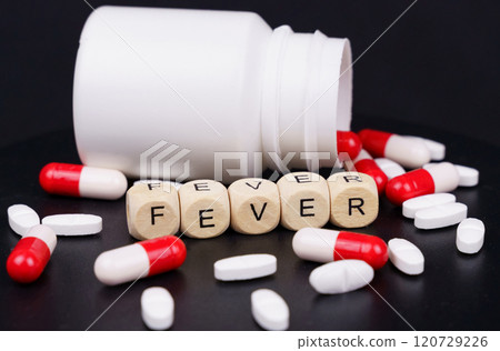 On a black background are red-white capsules, tablets, a jar and cubes with the inscription - Fever On a black background are red-white capsules, tablets, a jar and cubes with the inscription - Fever 120729226