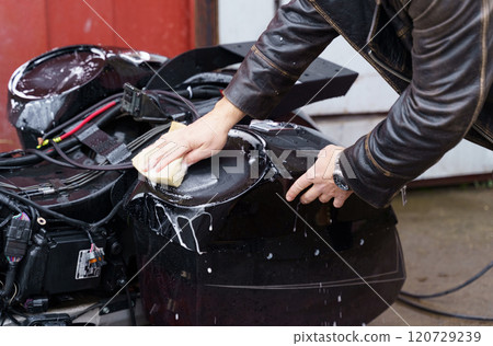 Washing a motorcycle with a high pressure jet. Washing a motorcycle with a high pressure jet. 120729239