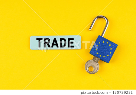 On the yellow surface is an open lock with a key and a sticker with the inscription - TRADE 120729251