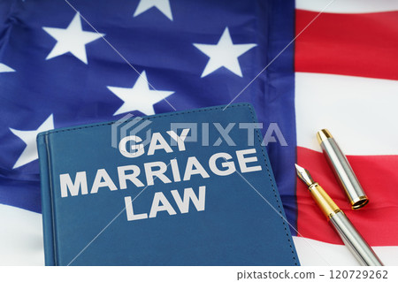 On the US flag lies a pen and a book with the inscription - GAY MARRIAGE LAW On the US flag lies a pen and a book with the inscription - GAY MARRIAGE LAW 120729262