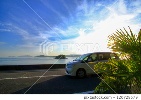 A car driving along the seaside under a refreshing sky 120729579